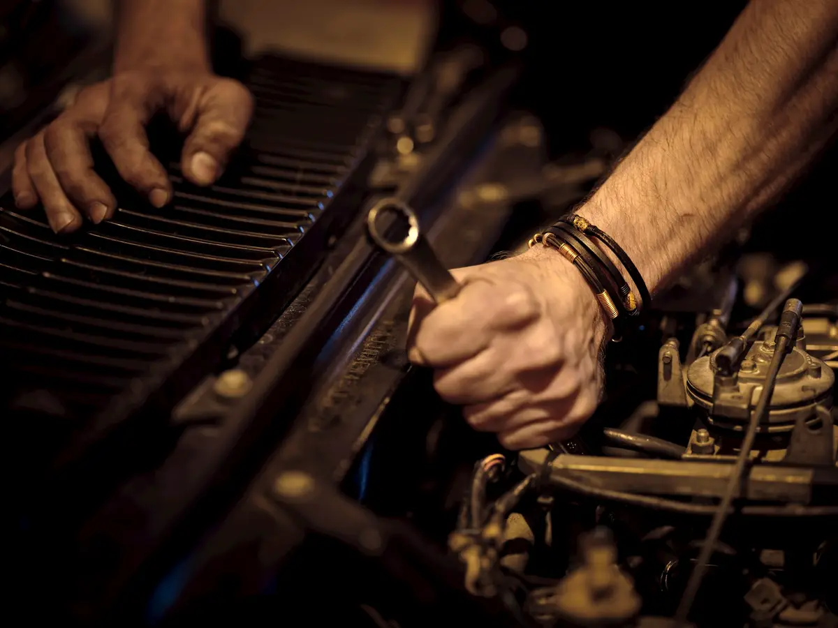 A technician working on an engine with a spanner